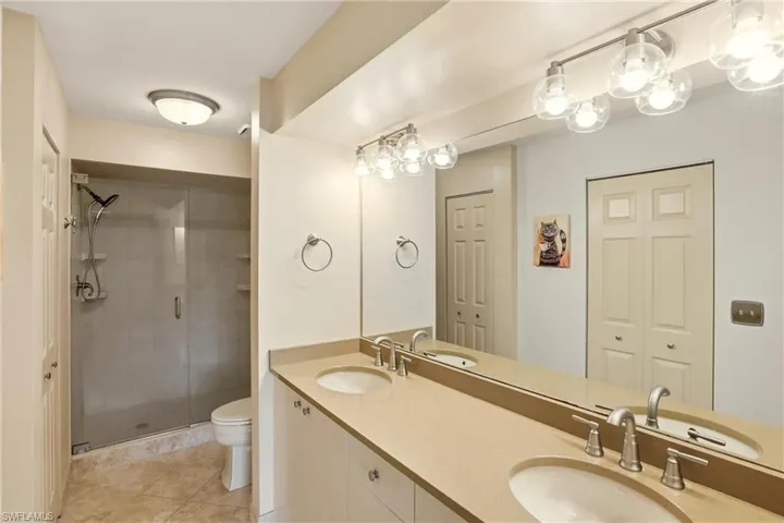 Bathroom featuring double vanity, walk-in shower