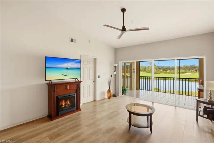 Living area with view of lake and golf course and fireplace