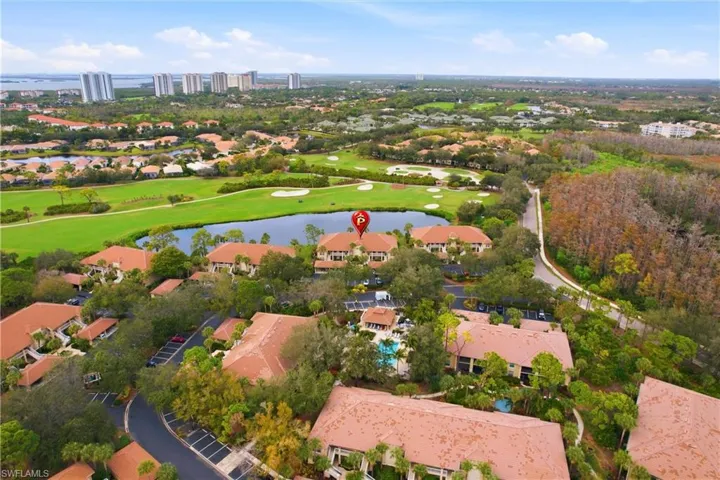 Aerial view of property and surrounding area with a nearby body of water, a local golf course, and nearby suburban area