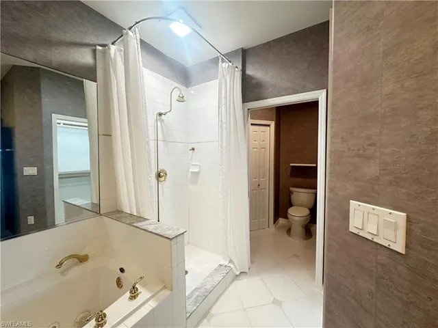 Bathroom featuring tile patterned floors, toilet, and independent shower and bath