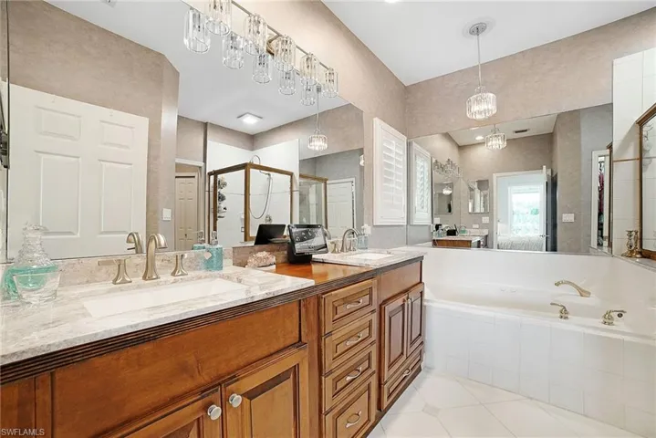 Bathroom featuring tile patterned flooring, separate shower and tub, and dual bowl vanity