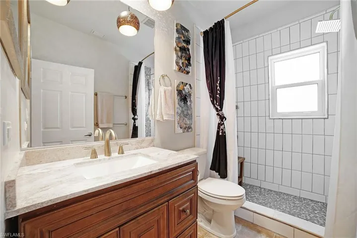 Bathroom with vanity, tile patterned floors, a shower with shower curtain, and toilet