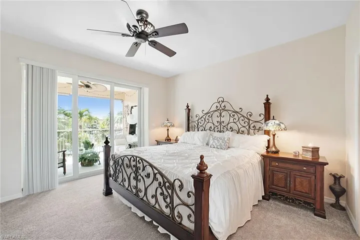 Carpeted bedroom with ceiling fan and access to exterior