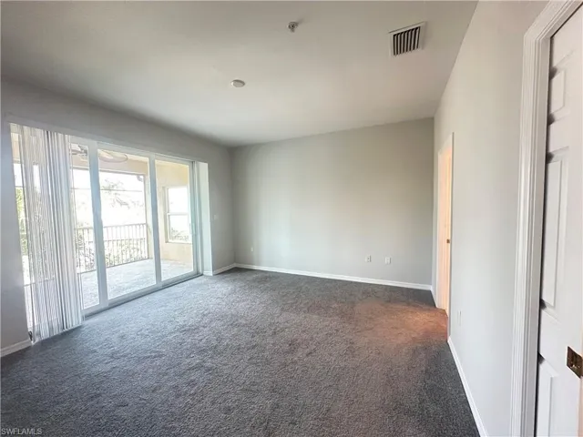 Unfurnished room featuring dark colored carpet