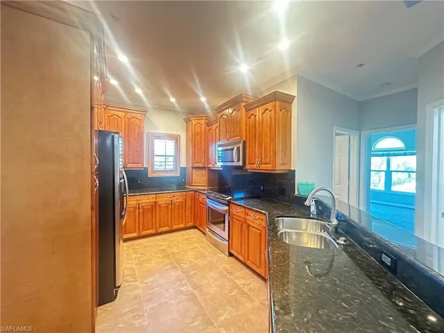 Kitchen featuring backsplash, stainless steel appliances, a healthy amount of sunlight, and sink