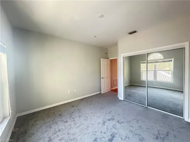 Unfurnished bedroom featuring carpet and a closet