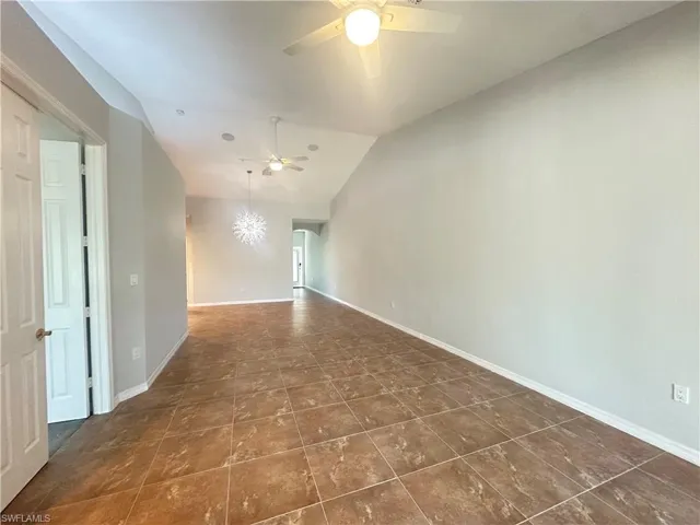 Unfurnished room featuring vaulted ceiling and ceiling fan