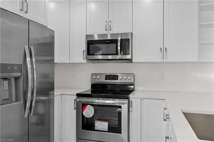 Kitchen featuring stainless steel appliances and white cabinetry