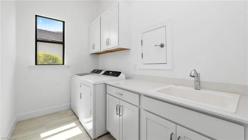 Laundry room featuring independent washer and dryer and cabinet space