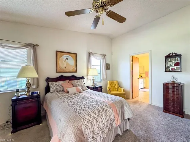 Bedroom featuring multiple windows, a textured ceiling, and ceiling fan