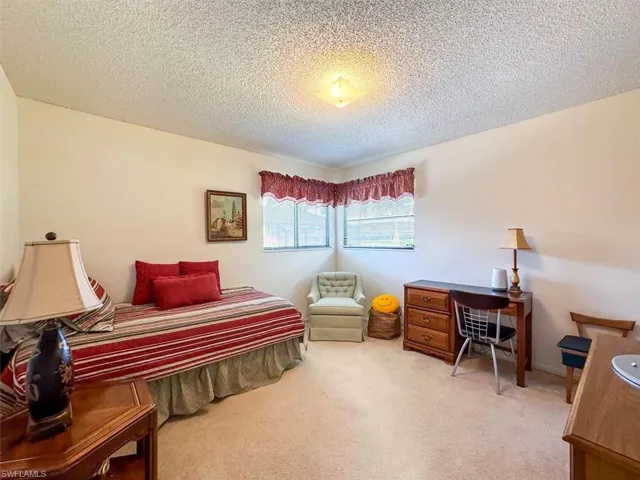 Carpeted bedroom with a textured ceiling
