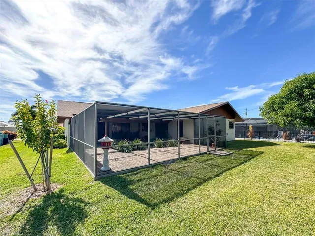 Back of house featuring a lanai, a patio area, and a yard