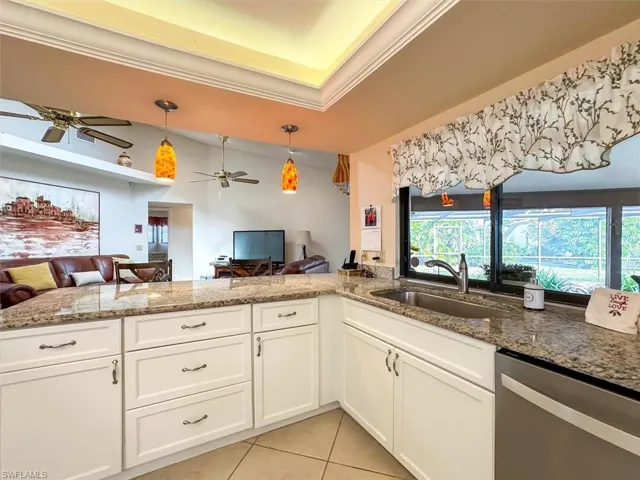 Kitchen featuring dishwasher, sink, a healthy amount of sunlight, and decorative light fixtures