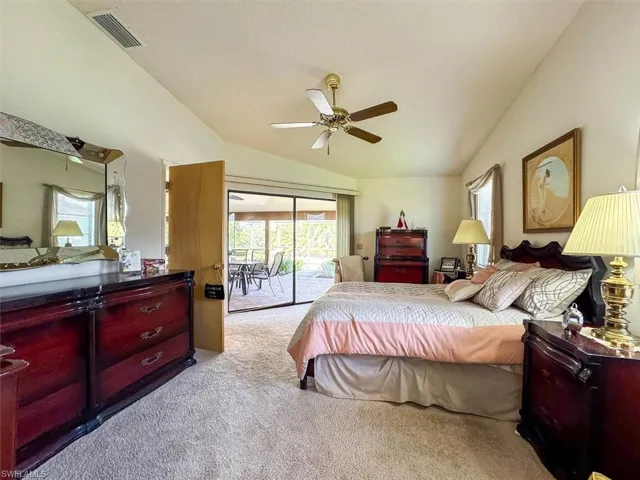 Bedroom with access to outside, ceiling fan, light carpet, and vaulted ceiling
