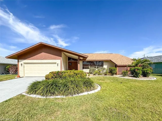 Ranch-style house with a front lawn and a garage