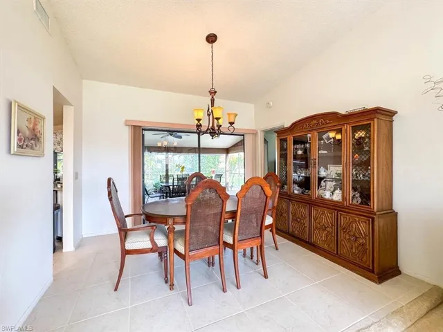 Tiled dining space with a notable chandelier and a textured ceiling