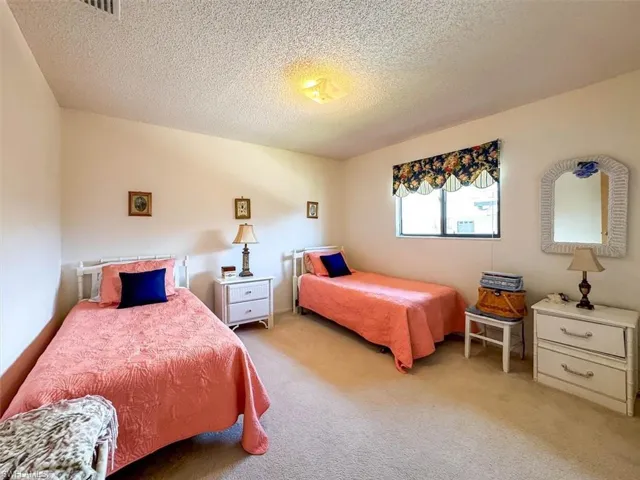 Bedroom featuring light carpet and a textured ceiling