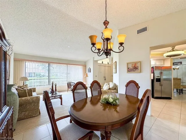 Tiled dining area featuring a chandelier and a textured ceiling