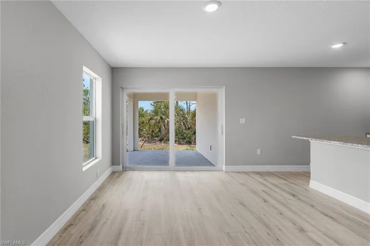 Spare room with light wood-style floors, baseboards, and recessed lighting