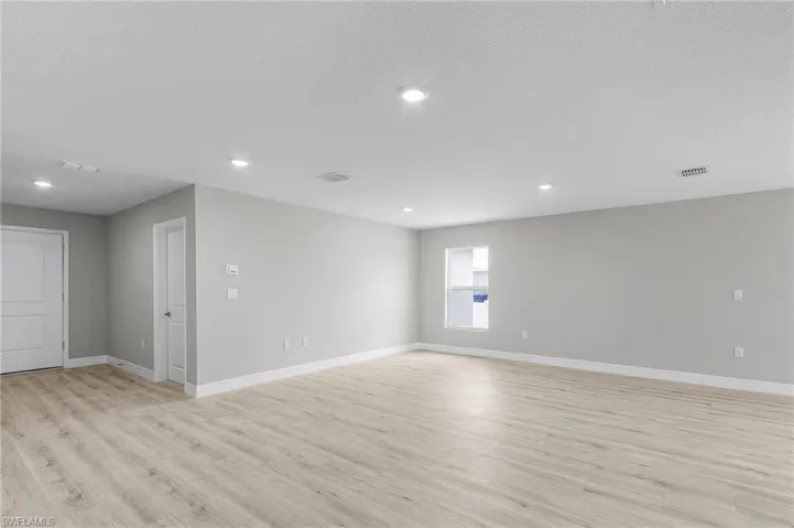 Unfurnished room featuring light wood finished floors, baseboards, recessed lighting, and a textured ceiling