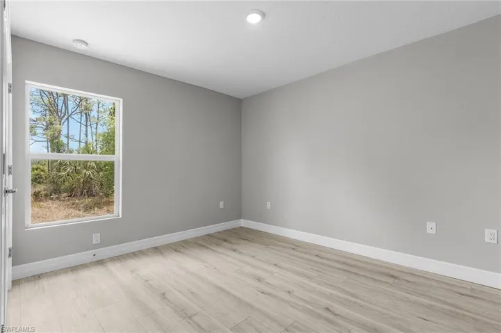 Spare room featuring light wood-style floors, baseboards, and recessed lighting