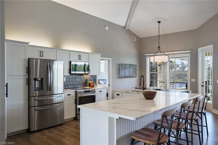 Kitchen with stainless steel appliances, a spacious island, tasteful backsplash, and a kitchen breakfast bar