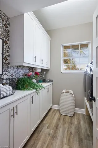 Washroom with light wood-type flooring and cabinet space