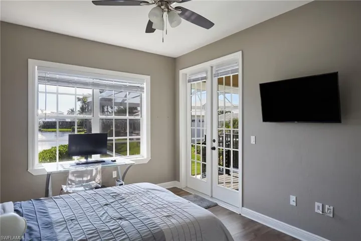 Bedroom with french doors, access to outside, multiple windows, and ceiling fan