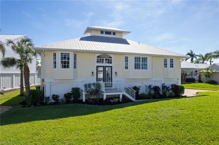 Split foyer home with a metal roof and a front yard