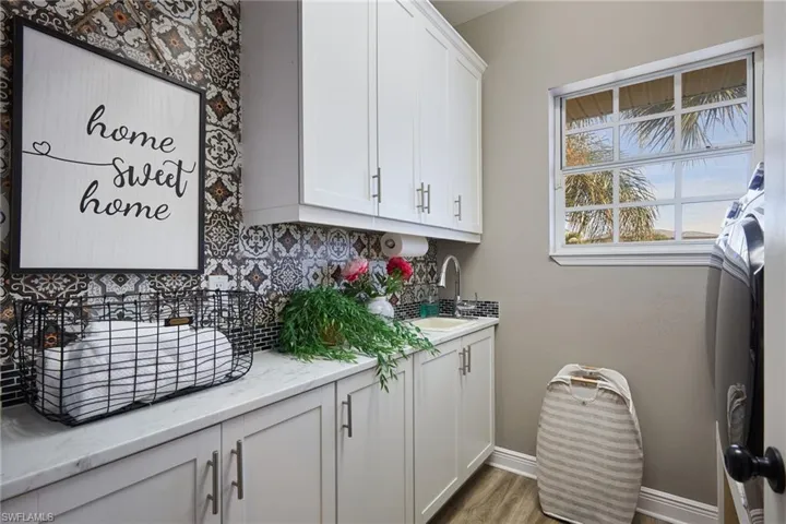 Laundry room featuring a sink and dark wood-style flooring