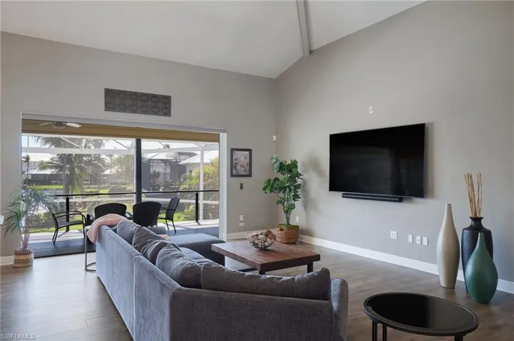 Living area with vaulted ceiling and wood finished floors