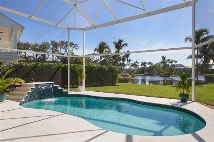 Swimming pool with a lanai, a lawn, a patio area, and a sunroom