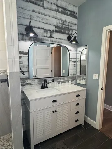 Bathroom featuring vanity and dark tile patterned floors