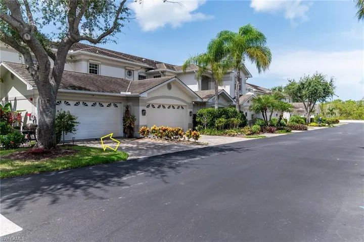 View of front of home with driveway, stucco siding, and a tile roof