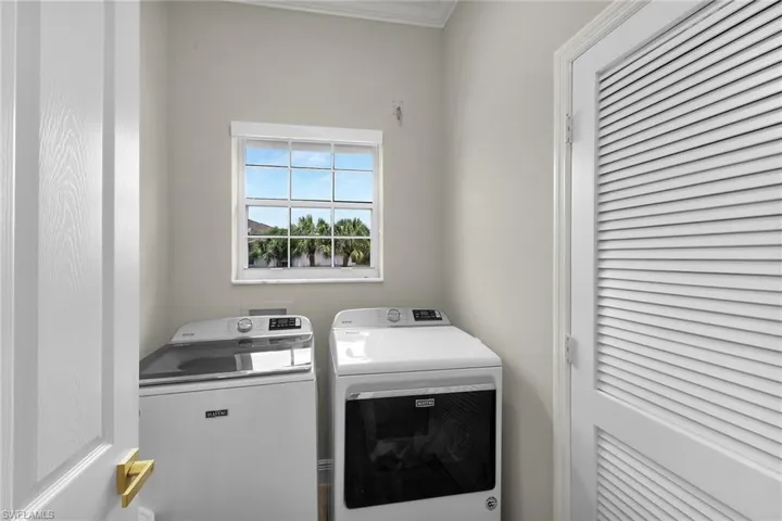 Laundry room featuring washer and dryer and crown molding