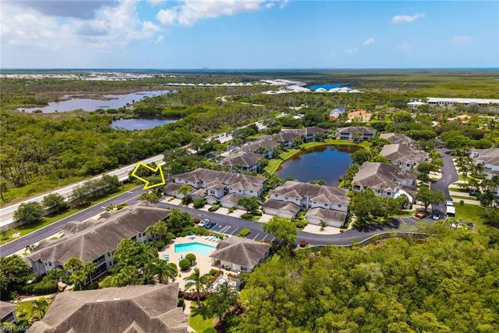 Aerial perspective of suburban area with a large body of water and a pool