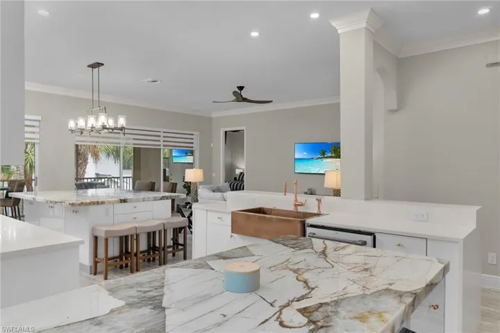 Kitchen with a center island, ceiling fan, white cabinetry, crown molding, and recessed lighting