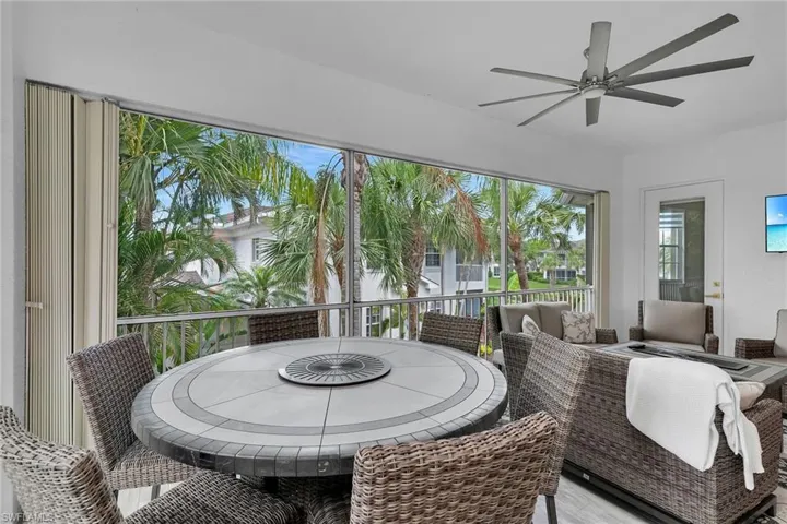 Sunroom / solarium featuring ceiling fan, outdoor dining space, and wood finished floors