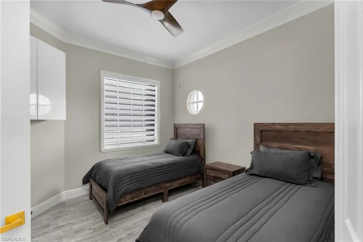 Bedroom featuring ornamental molding, light wood finished floors, and ceiling fan