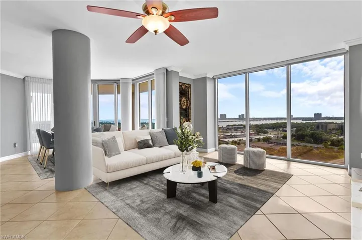 Living area featuring expansive windows, plenty of natural light, light tile patterned floors, ornamental molding, and a ceiling fan
