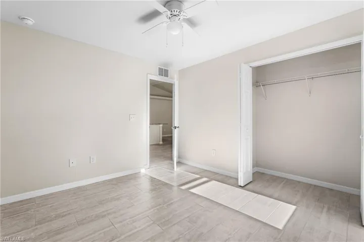 Bright interior space featuring light-toned walls, wood-finish flooring, and a ceiling fan