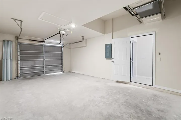 Spacious garage featuring a concrete floor, overhead lighting, and a panel garage door