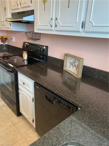 Kitchen featuring dishwasher, exhaust hood, black / electric stove, white cabinets, and light tile floors