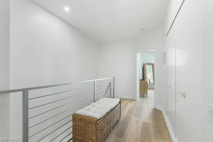 Corridor with light wood finished floors and recessed lighting