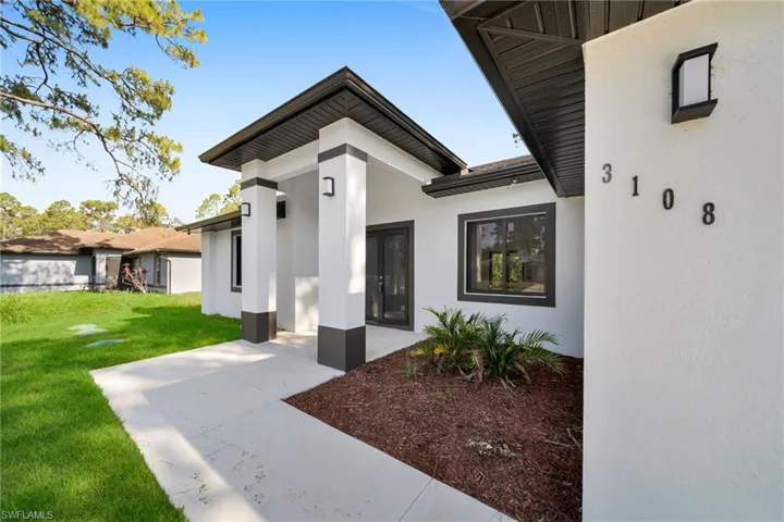 Doorway to property with stucco siding and a yard