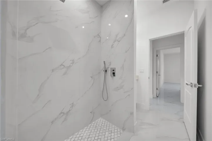 Bathroom with marble finish floors and a marble finish shower