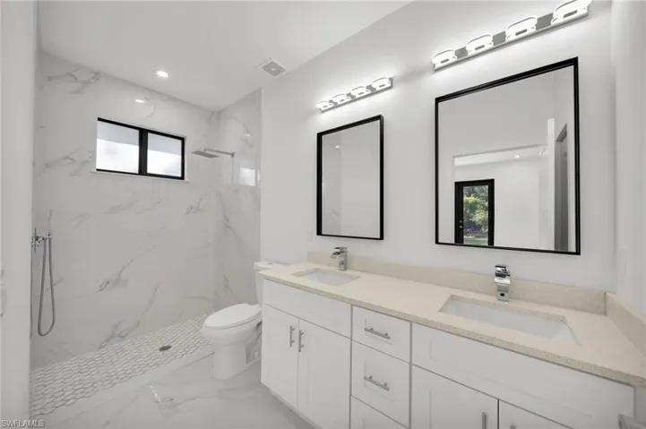 Full bathroom with marble finish flooring, plenty of natural light, toilet, a marble finish shower, and recessed lighting