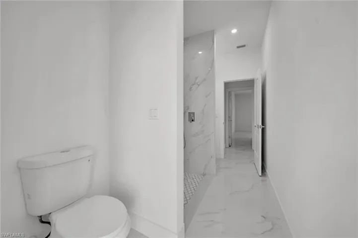 Full bathroom with marble finish floors, baseboards, toilet, recessed lighting, and a marble finish shower