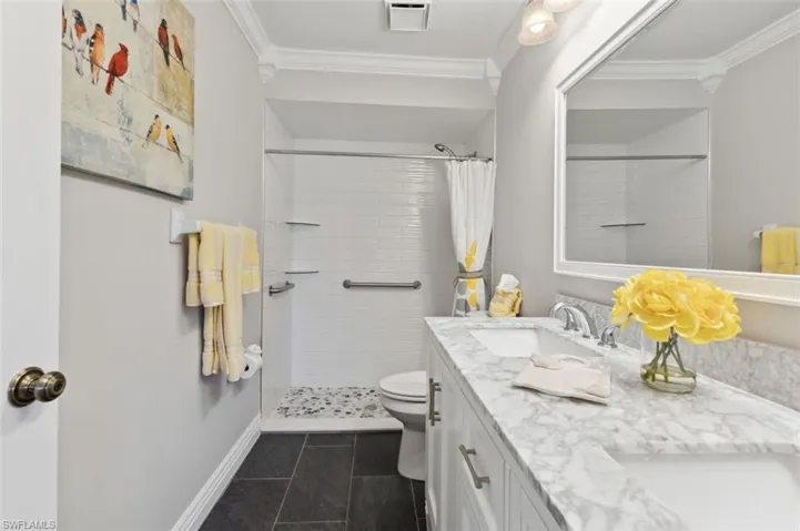Master Bathroom with ornamental molding, vanity, toilet, and a shower with curtain