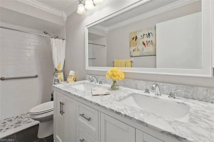Master Bathroom featuring toilet, tile patterned flooring, crown molding, vanity, and curtained shower